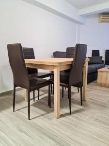 a wooden table with black chairs in a room at Apartamento Narcea in Benidorm