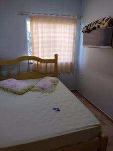 a bed in a small room with a window at Pousada Shalom in Barracão