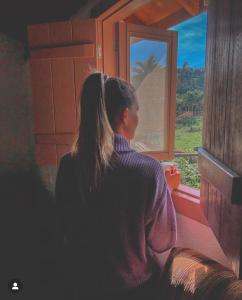 a woman looking out the window of a train at Sitio dos Palmitos - Casa Pupunha in Pedra Azul