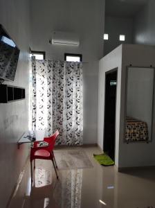 a room with a red chair and a mirror at Cahaya kos putri in Banda Aceh