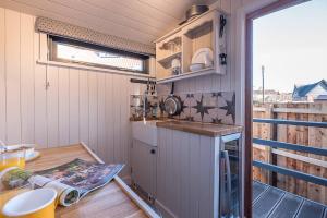 a kitchen with a counter and a sink in a tiny house at Bo Peep Shepherds Hut Thorpeness Air Manage Suffolk in Leiston