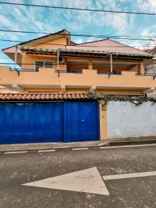 a house with blue garage doors on a street at The Bearded Dad Hostel in Tirana