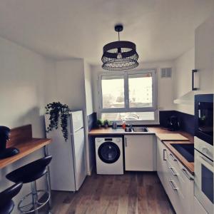 a kitchen with a refrigerator and a washing machine at Chambre Evasion Tout confort Saint Marceau in Orléans