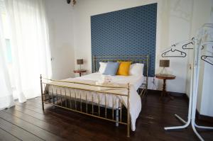 1 dormitorio con 1 cama con almohadas amarillas y pared azul en Cittadella Rooms, en Salerno