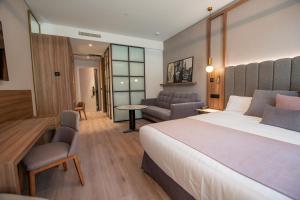 una camera d'albergo con letto e soggiorno di Hotel Giralda Center a Siviglia