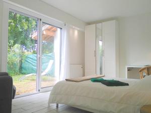 a bedroom with a bed and a large window at Le Baionarena 4 pers-terrasse-parking-hypercentre in Labenne