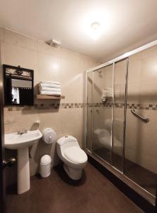a bathroom with a toilet and a shower and a sink at Hotel Casa Merced in Cuenca