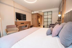 1 dormitorio con 1 cama blanca grande con almohadas en Hotel Giralda Center, en Sevilla