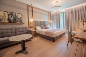 une chambre d'hôtel avec un lit et un canapé dans l'établissement Hotel Giralda Center, à Séville