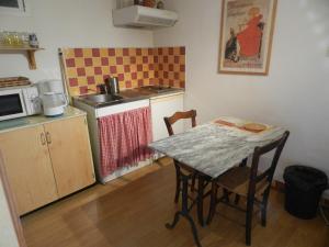 een kleine keuken met een tafel en een fornuis bij La Ferme Montplaisir in Montesquieu-Volvestre