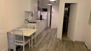 a small kitchen with a table and a table and chairs at Delante del Mar in Lloret de Mar
