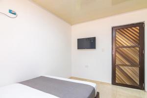 - une chambre avec un lit et une télévision murale dans l'établissement Hotel Casa Guajira Real, à Ríohacha