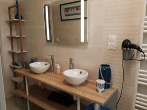 een badkamer met 2 witte wastafels en een spiegel bij GÎTE DU BOUYSSOU in Carsac-Aillac