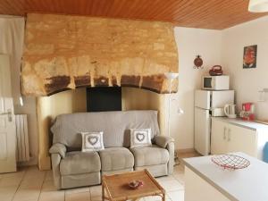 a living room with a couch and a fireplace at GÎTE DU BOUYSSOU in Carsac-Aillac
