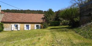 an old brick house with a grassy yard at GÎTE DU BOUYSSOU in Carsac-Aillac