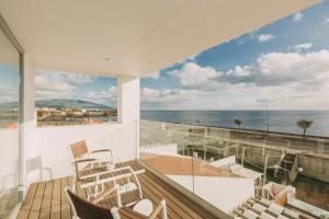 a balcony with chairs and a view of the ocean at Coast Flats by Azores Villas in Ponta Delgada