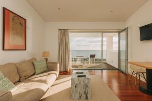 Coast Flats by Azores Villas في بونتا ديلغادا: غرفة معيشة مع أريكة وطاولة