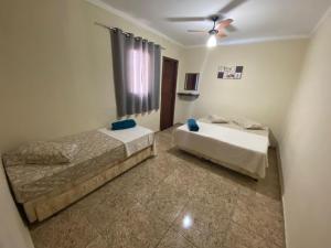 1 Schlafzimmer mit 2 Betten und einem Deckenventilator in der Unterkunft Pousada Mãe Padroeira in Aparecida