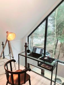 a desk with a laptop and a chair in a room with a window at Stara Izba samotnia blisko natury in Aleksandria