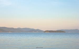a large body of water with mountains in the background at Pousada Casa do Oscar in Governador Celso Ramos