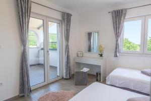 a white room with a bed and a window and a bathroom at Villa Antea - privat heated pool, brand new villa, relaxing, rural near sea in Imotski +30 photos