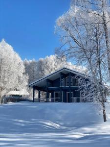 una casa azul con nieve en el suelo en Эко-клуб Голицыно, en Mikhaylovka