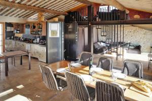 a dining room with a table and chairs and a kitchen at Scenic Village Home with Lake Panorama in Sainte-Croix-de-Verdon