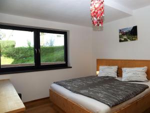1 dormitorio con 1 cama y 2 ventanas en Apartment Lemberger en Mittersill