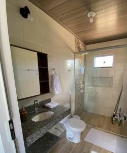 a bathroom with a toilet and a sink and a shower at Chalés Recanto da Baleia in Alto Paraíso de Goiás