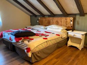 een slaapkamer met een groot bed met een houten hoofdeinde bij Chalet Capannina in Sauze dʼOulx