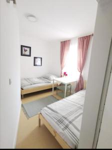 a room with two beds and a table and a window at ApartGraz in Graz