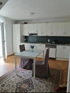 eine Küche mit einem weißen Tisch und 2 Stühlen in der Unterkunft ApartGraz in Graz