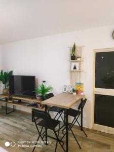 a dining room table with chairs and a television at אלת המדברGoddess of the desert in Beʼer Ora