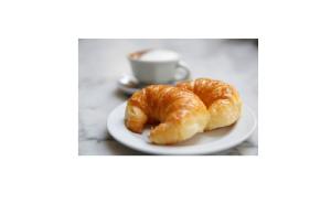 due croissant su un piatto con una tazza di caffè di Bed & Breakfast Delta Inn - Río Tigre a Tigre