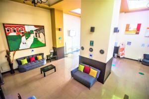 a waiting room with couches and a painting on the wall at Hotel Plaza Mirador in M&eacute;rida