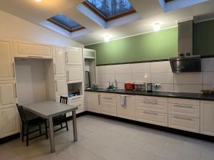 a kitchen with a table and a green wall at city-pillow rooms in Luxembourg