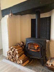 a fireplace with a pile of fire wood at Cottage 33 Westhoek in Alveringem