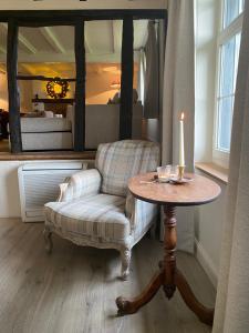 a living room with a chair and a table with a candle at Cottage 33 Westhoek in Alveringem