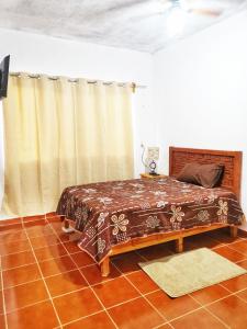 a bedroom with a bed in a room with curtains at Estancia Flores1 in Tepoztlán