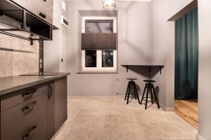 uma cozinha com um balcão e dois bancos em Revolution Aparts - Studio em Lódź