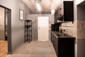 uma cozinha com balcões pretos e uma porta branca em Revolution Aparts - Studio em Lódź