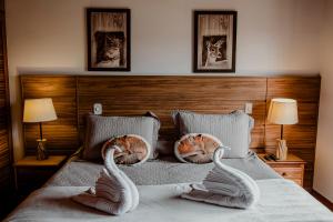 zwei Schwäne auf einem Bett in der Unterkunft Ville de France in Campos do Jordão