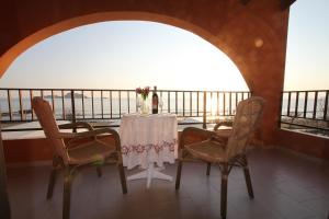 a table and chairs in a room with a balcony at PORTO-FINO in Arillas