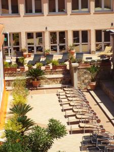 une rangée de chaises bordées devant un bâtiment dans l'établissement Le Nereidi Hotel Residence, à La Maddalena