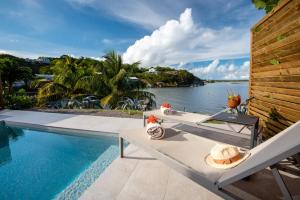 uma mesa com um chapéu ao lado de uma piscina em EAST KEYS - East Lagoon Suites em Le François