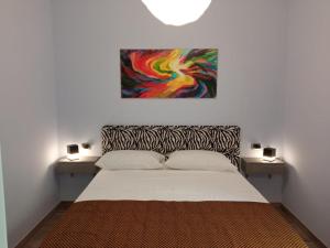 um quarto com uma cama com um quadro na parede em Cappuccini Garden House em Pozzuoli