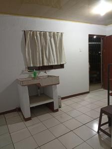 um quarto com uma mesa e uma cortina na parede em Departamentos Patricia em Alajuela