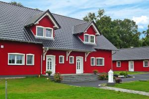 una casa roja con techo gris en Apartments Spreeidyll, Schlepzig, en Schlepzig