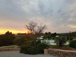 a sunset over a swimming pool and a resort at Tenuta La Milogna in Gallipoli