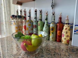 a bowl of fruit on a counter with wine bottles at PISO VOLVORETA in O Grove